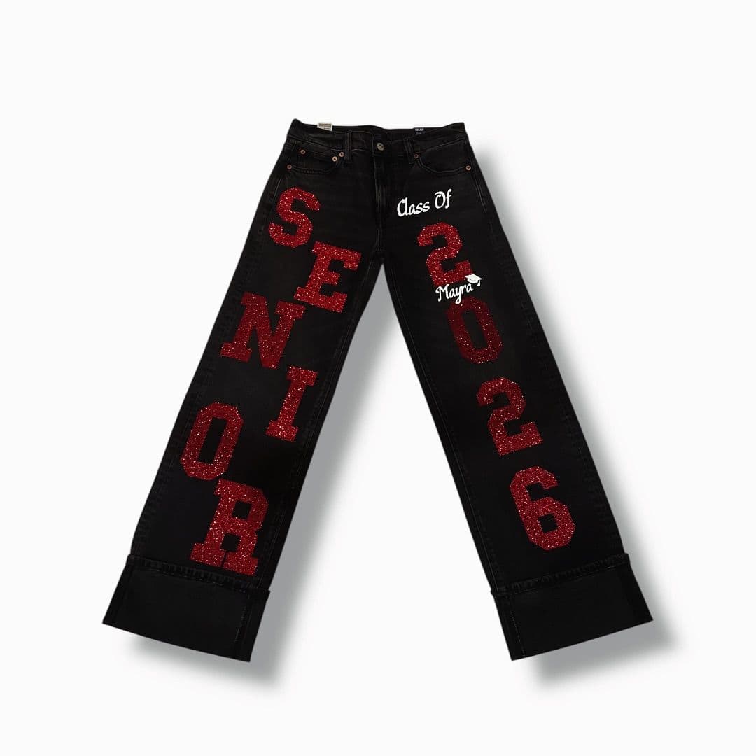 Black jeans with red glitter “Senior 2026” lettering down the legs
