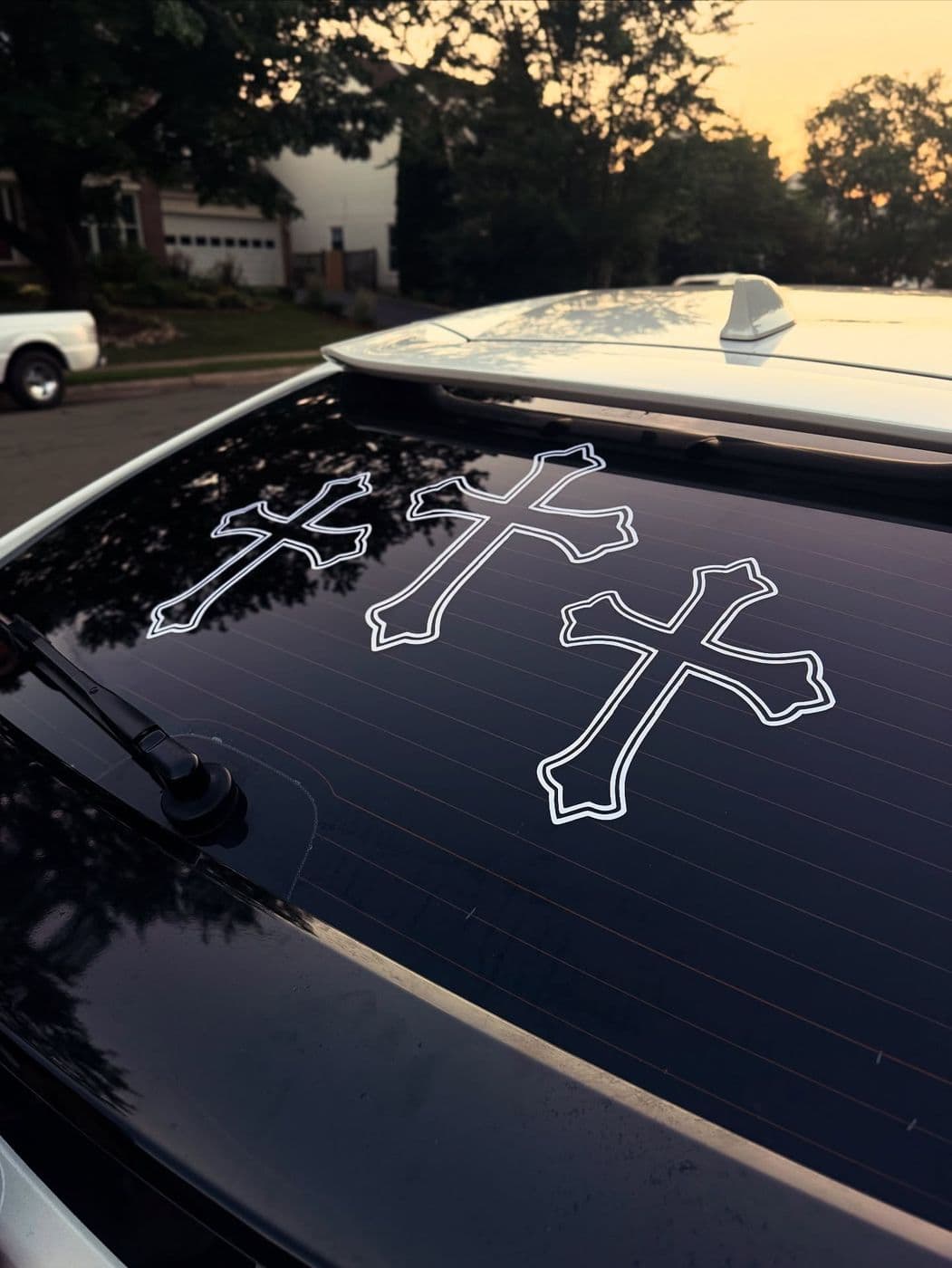 White outline cross decals on a car’s rear window