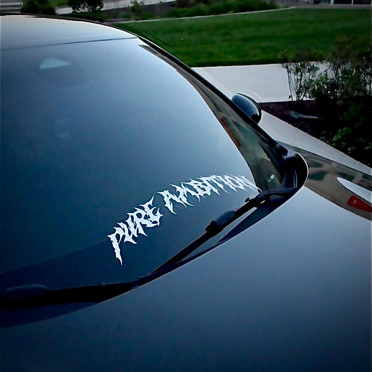 “Pure Ambition” holographic windshield banner on a black car